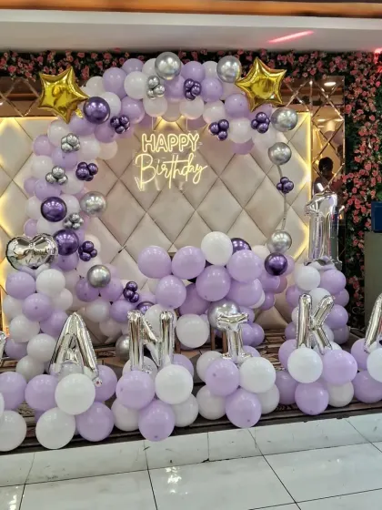 Another view of the purple and white birthday decoration for Vanika. This setup against a mirrored and floral wall looks very grand and is perfect for a special celebration.