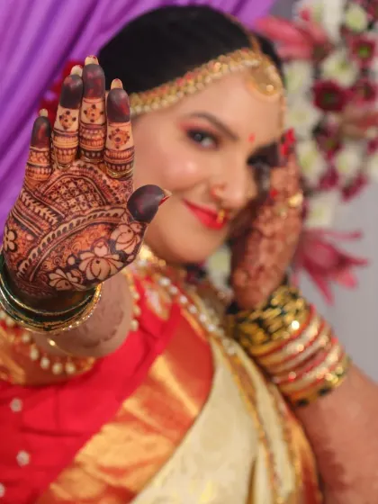 A playful pose that puts the intricate palm henna in focus. The design is dense and detailed, exactly what a bride dreams of for her wedding day.
