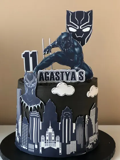 Wakanda Forever! A sleek Black Panther cake with a city skyline silhouette and the iconic mask.
