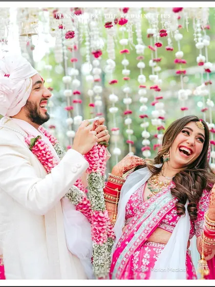 A moment of pure laughter and joy during the Varmala ceremony, showcasing the fun and playful side of the couple's relationship.
