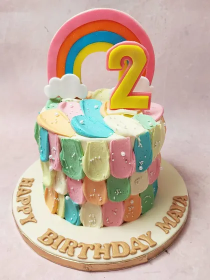 We paint with all the colors of the rainbow on this abstract and artistic birthday cake. Colorful buttercream scales and smudges create a unique texture, topped with a bright rainbow and the number "2" for a vibrant and playful celebration.