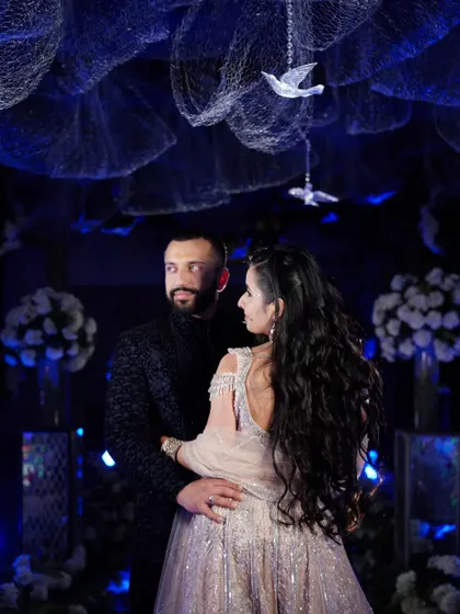 A romantic portrait of the couple during their Sangeet, with the deep blue decor creating a dreamy, celestial atmosphere.