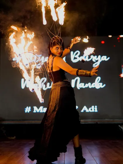 A female fire dancer captivates the audience with her performance. The dramatic lighting and custom screen in the background are all part of the complete production I manage.