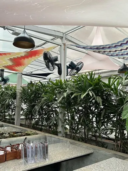 We used rows of Areca palms and other leafy plants in built-in planters to create a lush, tropical feel at 'The Big Barn' pub. This design helps to screen the area and make the outdoor seating feel more private and secluded.