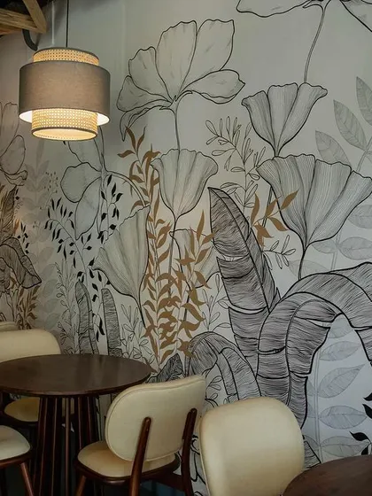 A custom hand-painted mural adds a layer of artistry and biophilic design to the President Cafe. The monochrome floral pattern creates a serene and visually engaging backdrop for diners.