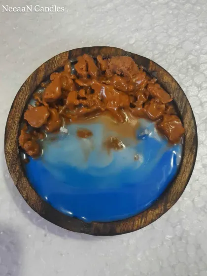 Drift away to the shore with this beach vibe candle. Set in a wooden bowl, it captures the ocean with blue wax and a sandy shore made of wax crumbles.