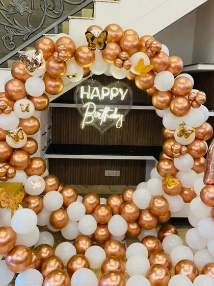 An elegant rose gold and white themed birthday. This circular balloon arch is perfect for a sophisticated celebration, complete with a champagne bottle balloon.