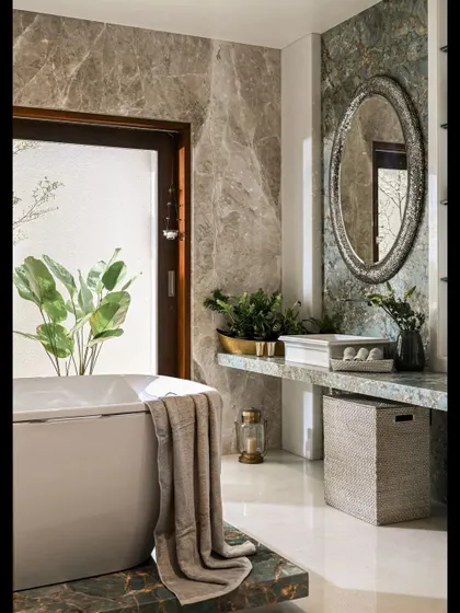 Natural materials bring a sense of calm to a bathroom. Here, we used two types of marble with beautiful natural veining on the walls and bathtub surround. The large window opens to a private green space, enhancing the feeling of a natural retreat.