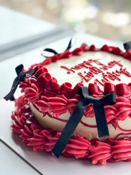 I love a good vintage buttercream and bow moment. This design features rich red buttercream piping with delicate black bows, perfect for a romantic and stylish "happy birthday wifey" cake.
