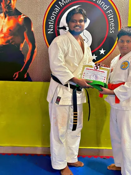 This student receives his orange belt, marking his advancement and dedication to Karate.