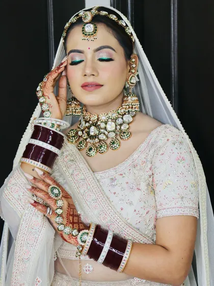 A close-up of the bride's makeup. The pop of green liner adds a modern twist to the traditional bridal look.