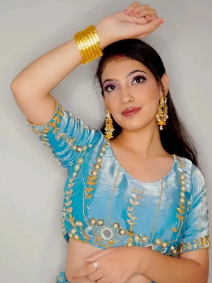 A close-up look at the stunning details of this powder blue lehenga. The blouse features intricate embroidery and mirror work, perfect for a festive occasion.