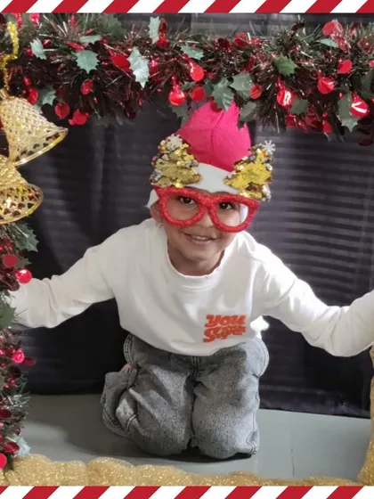 A child shows off his fun Christmas-themed glasses in the photo booth.