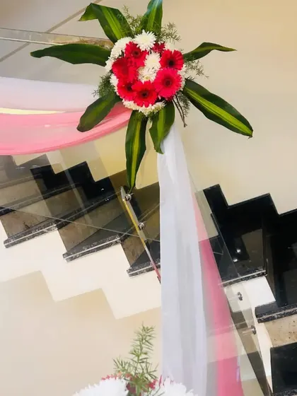 A close-up of a floral bouquet used for railing decor. The combination of red and white flowers with green leaves is classic and beautiful.