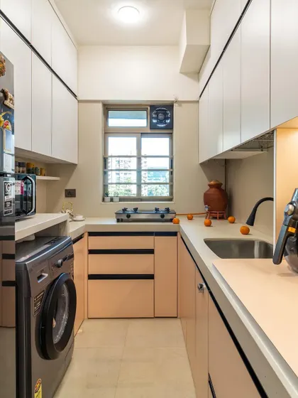 This compact kitchen layout makes the most of every inch, with ample storage, a dedicated spot for the washing machine, and plenty of counter space.
