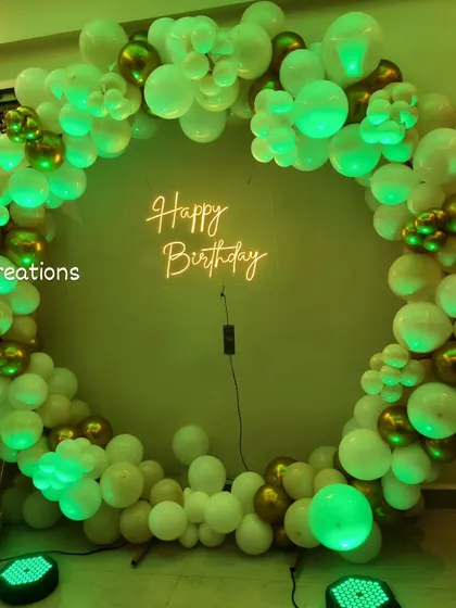 The versatile white and gold balloon circle again, this time under a vibrant green light for a different party vibe.