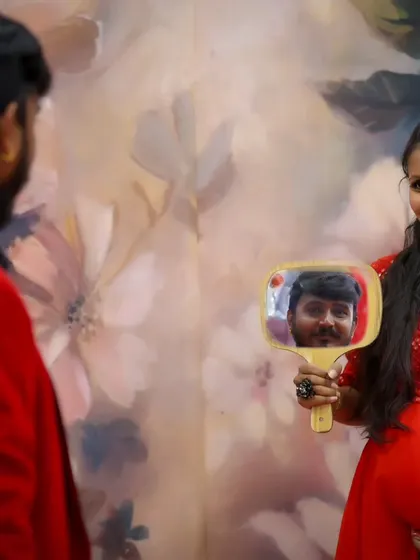 A creative and sweet shot where the father-to-be's reflection is captured in a mirror held by the mother-to-be.