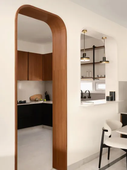 The view from the dining area into the kitchen, framed by a beautiful wooden archway. This design choice creates a graceful transition between the two spaces.