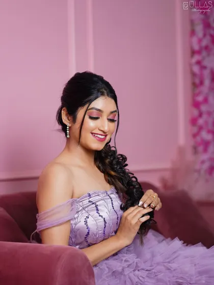 The details of the makeup and hairstyle pair perfectly with the off-shoulder ruffle gown.