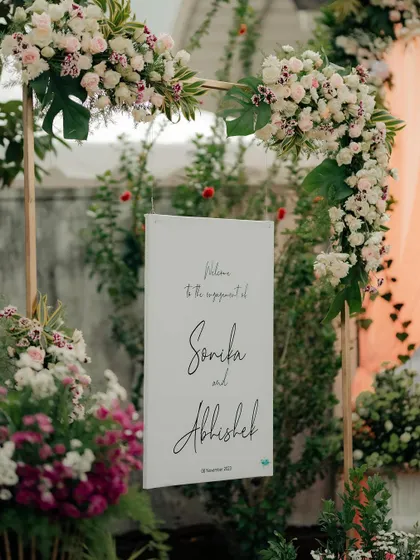 Personal touches make an event unique. For Sonika and Abhishek's engagement, we designed this elegant welcome sign, framed with an arch of exotic white and pink flowers that set a romantic tone from the moment guests arrived.