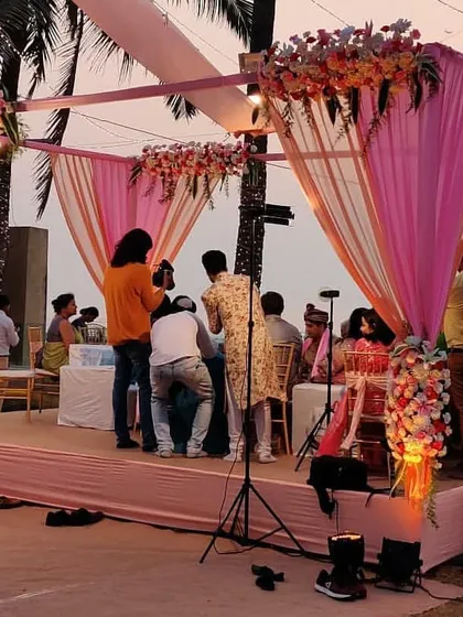 This photo captures a moment during the wedding ceremony inside a beautiful pink and peach mandap. Our designs always ensure there is ample space and a beautiful backdrop for photographers to capture these precious moments.
