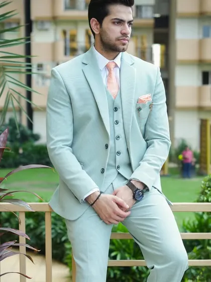 A model looking relaxed and stylish in our light mint green three-piece suit.