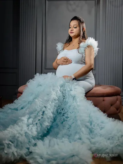 A serene and beautiful shot of the client in her light blue maternity gown. The makeup is soft and glowing, enhancing her peaceful expression.