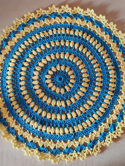 The completed blue and yellow doily, a small piece made with heartfelt intentions. Crochet can be a very meditative and calming craft.