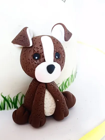 A detailed shot of the cute, handcrafted dog topper. It's these personal touches that tell a unique story for each birthday.