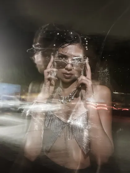 An experimental portrait using a slow shutter speed and camera movement to create a ghostly, energetic light trail effect. This is pure visual art.