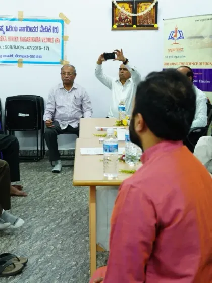A practical session during the Prāṇa Sañjīvini launch event, where senior participants are guided through a simple breathing technique. It is never too late to start the journey of yoga.