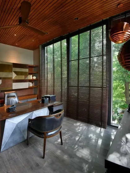 The large windows of the T House study can be covered with wooden blinds, allowing for control over the light and mood of the space.