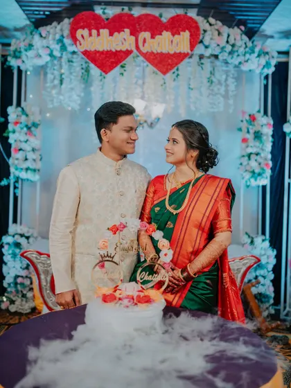 A smiling portrait of the couple behind their engagement cake.