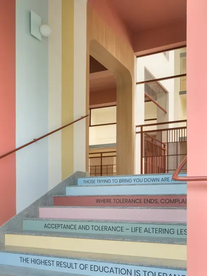 The colorful steps of the stairway, each carrying a message about tolerance and personal growth. The pastel stripes on the wall add to the cheerful and uplifting feeling of the space.