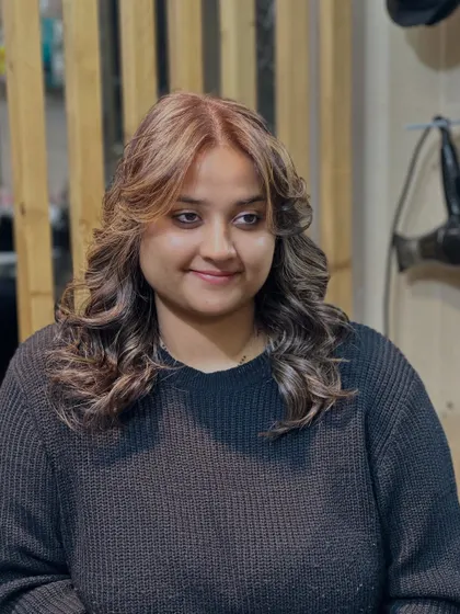 A close-up of a finished balayage and haircut. Notice the soft blend of colors and the healthy shine, complemented by a layered cut that adds volume and shape.
