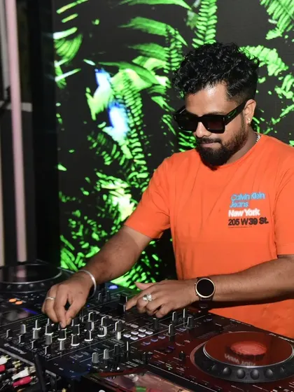 Mixing tracks in front of a tropical-themed LED background. It's all about the vibe.