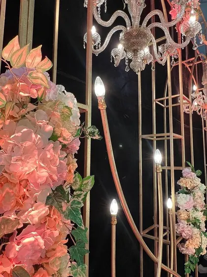 This reception stage was designed for a live band performance. I used an elegant framework with chandeliers and floral arrangements against a black backdrop for a dramatic and stylish effect.