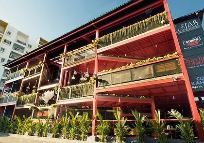 The exterior of Big Pitcher, Sarjapur, where we used landscaping to soften a large, industrial-style building. Rows of planters with tropical foliage create a green facade that welcomes guests.