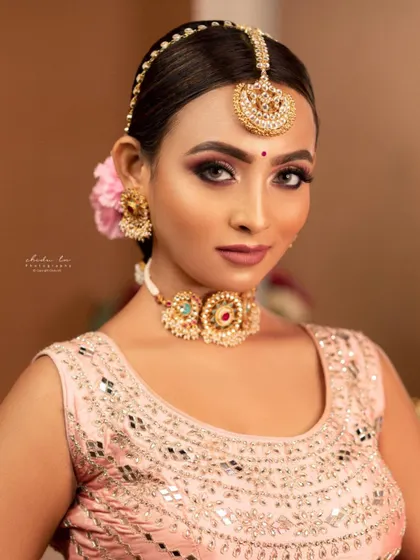 This lightweight choker set with Meenakari details is a great rental option for pre-wedding events like Haldi or Mehendi. The simple maang tikka and matching earrings complete the look without being overpowering.