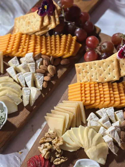 A close-up of our classic cheese and charcuterie board, featuring a selection of premium cheeses, crackers, nuts, and grapes. This was part of our catering for Netflix's 'Fabulous Lives of Bollywood Wives'.