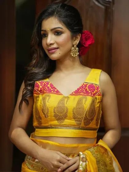A sleeveless yellow blouse with a V-neck and a beautiful paisley brocade pattern.