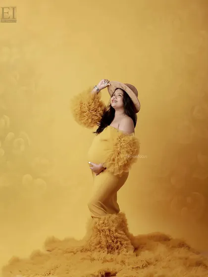 Accessorizing the yellow gown with a stylish hat for a fashionable and fun studio portrait.