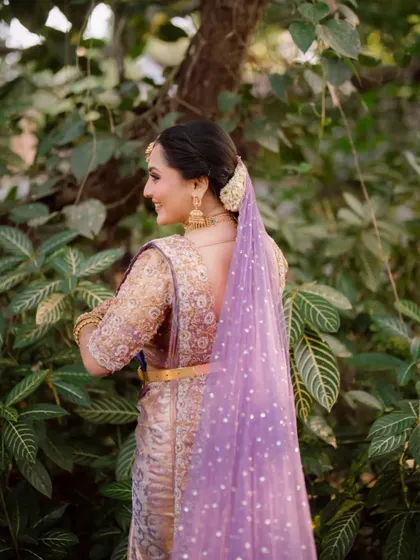 A back view of the bride's stunning saree and hairstyle, showcasing the intricate details of her look.