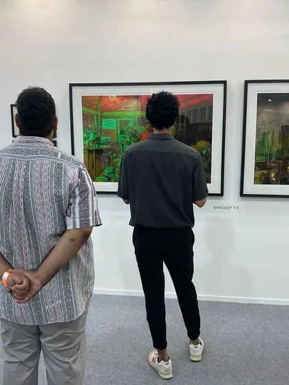 Visitors looking at the vibrant, layered photographs by Sandeep T K.