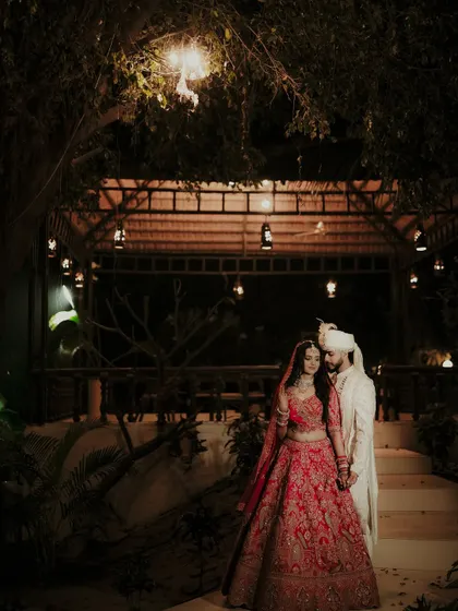 A nighttime portrait under a beautifully lit gazebo. I use the warm, ambient lighting to create a romantic and intimate atmosphere, capturing the couple in their stunning wedding attire after the ceremony.