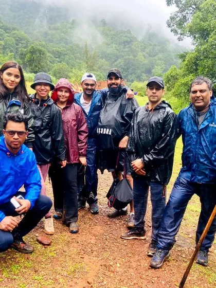 A group photo of a team in raincoats during the Kodachadri trek. We brave the elements together, strengthening the team's bond.