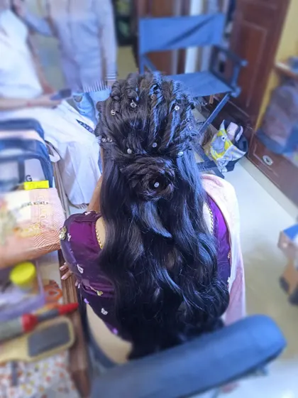 A unique half-up style featuring a rose-shaped bun and intricate braids, with the rest of the hair left in soft waves. This creative style is perfect for a bride who wants something different.