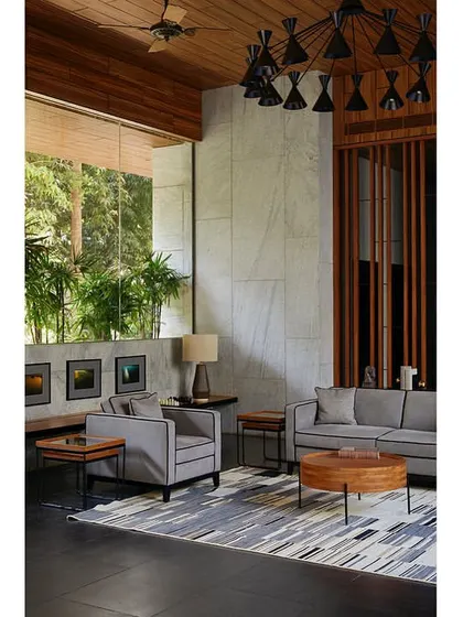 The garden lounge is a comfortable and utilitarian space designed for meetings, parties, or relaxation, featuring a wood-clad ceiling and a custom chandelier.