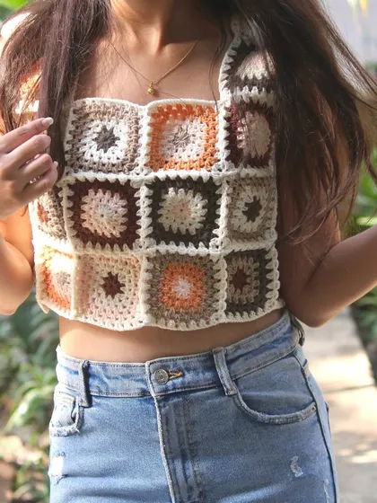 My granny square crop top is a true labor of love and one of my most popular wearable pieces. I carefully craft each square in earthy tones and stitch them together to create this boho-style top, perfect for sunny days.