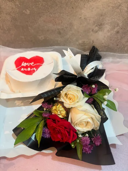 An elegant gift hamper with a "Love" bento cake and a stunning bouquet of red and white roses.